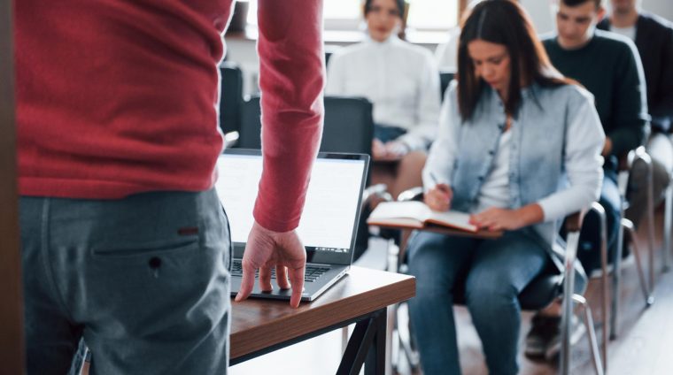 speaker-uses-laptop-group-people-business-conference-modern-classroom-daytime